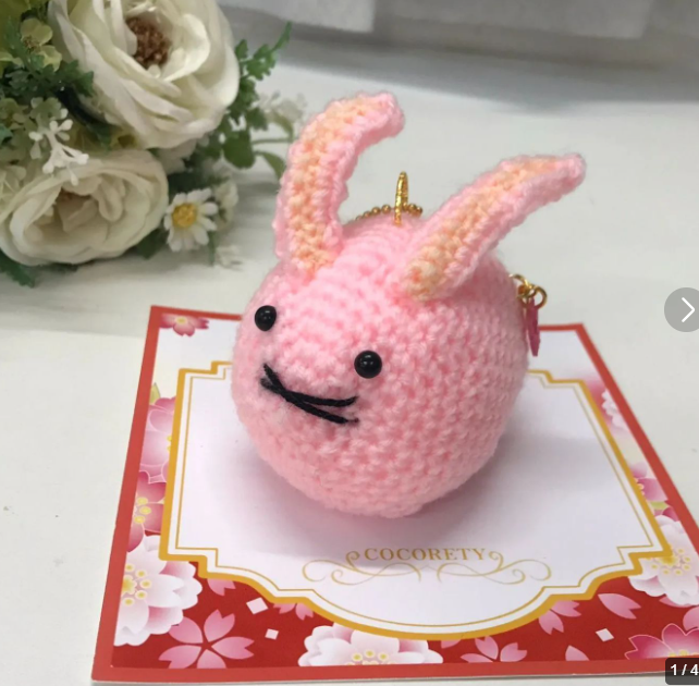 桜をイメージした淡い色合いで編まれた、可愛らしいうさぎのあみぐるみ