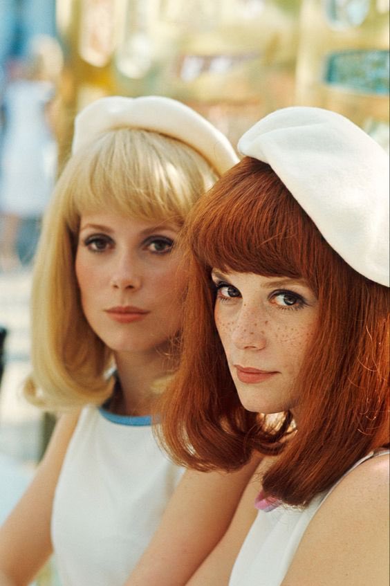 Catherine Deneuve &amp; Françoise Dorléac on the set of Umbrellas of Cherbourg, 1967.