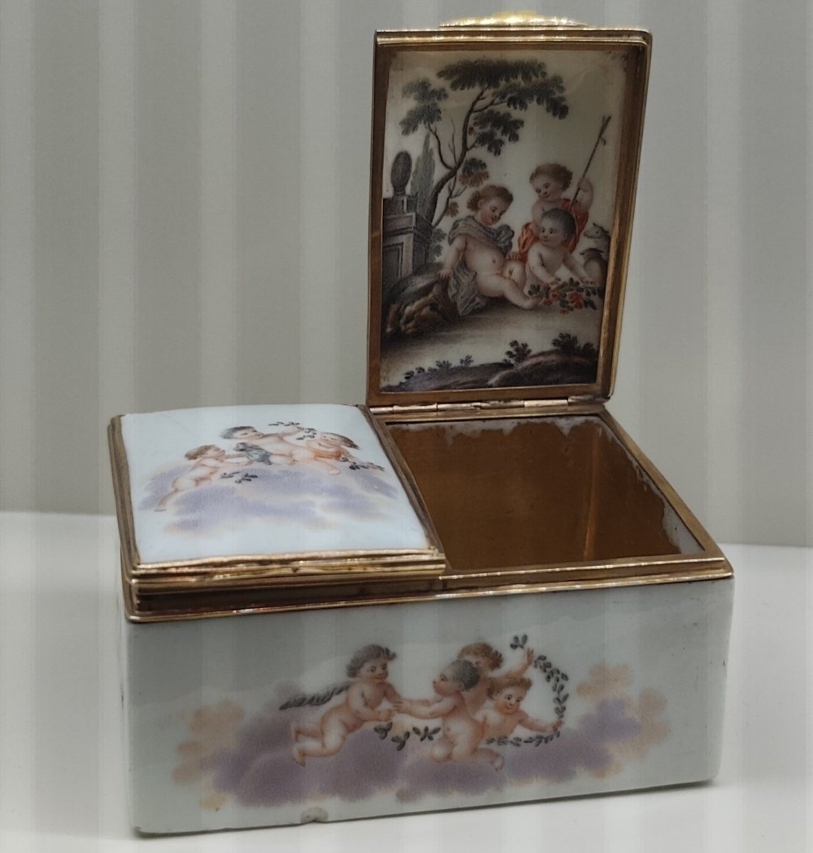 Esta bonita caja de porcelana y oro de la Real Fábrica de Porcelana del Buen Retiro pertenece al S XVIII y servía para guardar rapé, una droga a base de tabaco molido, la cual era esnifada por la aristocracia de la época , pues proporcionaba euforia y despejaba la mente.