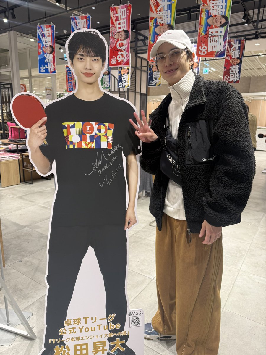 TPlus_SBD's tweet photo. 公式YouTube番組「Tリーグ卓球エンジョイ大使への道」に出演中の #松田昇大 さん（@MatsuS_official ）が、新宿マルイ本館の #TPlus POP UP STOREになんと2度目のご来店👀⁉️

展示中の等身大パネルの日にちを書き直しに来てくれました笑
誤)2/24→正)3/24

ありがとうございます🏓

#Tリーグ #卓球 #新宿マルイ