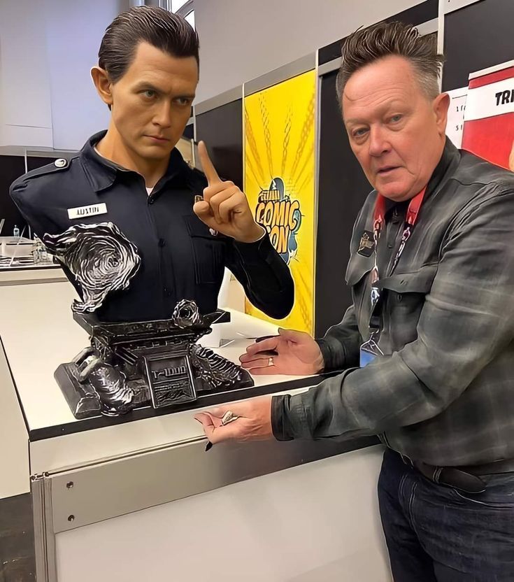 Actor Robert Patrick posing with a bust of his iconic T-1000 character from Terminator 2.