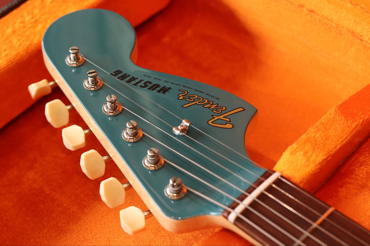 shu_ot's tweet photo. 「御召茶（おめしちゃ）」 200本限定！Fender Custom Shop『Free Spirits (Char Signature Mustang) 』のDead Stock(未使用品)が入庫、八戸店とデジマート店にて396,000円税込にて販売中で御座います💁‍♂️

お知らせ
当店では『楽器や機材の買取り』『楽器の委託販売の依頼』を常時受付中で御座います。

『思い入れのある楽器達を大切に扱って欲しい』『出来るだけ高額で販売したい』そんな方は是非当店へご相談頂けますと幸いです。

また『壊れている弦楽器』『経年でサビや埃を被っている楽器』も遠慮無くそのままお持ち下さいませ。

Free Spirits について
厳選された極上のマテリアルで製作された Char氏がデザインする究極のムスタング『Free Spirits』の中古未使用品が奇跡的に入荷致しました。極上2Pアルダーに加えネック材は希少なクォーターソーン・メイプル(柾目)となっており更に程良くトラ目が入っています。

画期的な「FREE SPIRITS スイッチング」システムを搭載。2つのスライドスイッチの組み合わせにより、通常の「フロント/リア/並列ミックス（正相・逆相）」に加え、2基のシングルコイルを直列に接続する「擬似ハムバッカー（シリーズ）モード」を含む計5通りの多彩なサウンドバリエーションが可能でございます。

また、ブリッジをあえて逆向きに設置する「フリップ・インターチェンジブル・ブリッジ」を採用しています。

傷などの状態
デッドストック品なので非常に綺麗な状態です。ピックガードの保護フィルムは先程剥がしました。極薄のニトロセルロースラッカーを採用し出荷時の時点で既に光を当てると細かい「バフ目」が無数に入っております。いわゆるカスタムショップ「NEW OLD STOCK」独自の反射し過ぎない絶妙な光沢具合となっております。

楽器としての状態
ネックはストレート、トラスロッドの可動域には充分な余裕が御座います。フレットの減りは未使用品なので御座いません。弦高は12フレット上で6弦2.0mm 1弦1.5mm となっております。大変弾きやすい最高なコンディションで御座います。

純正ハードケース、認定証（Char氏、Mike Eldred氏サイン入り•フォト）各ノベルティが付属致します。

Char氏のデビュー35周年プロジェクトの集大成として製作された、世界200本限定の究極のムスタングです。Char氏の愛機である1964年製ムスタングのダフネ・ブルーが経年変化した渋みのある色合いを、日本の伝統色「御召茶（おめしちゃ）」で再現。

マッチングヘッド仕様。カスタムショップならではのNOS（New Old Stock）仕上げにより、しっとりとした光沢を放ちます。厳選されたクォーターソーン・メイプルネックや、専用のハンドワウンド・ピックアップなど、ヴィンテージへの敬意と現代的な機能美が融合した、プレイヤー・コレクター双方にとって究極の一本と言えるモデルです。