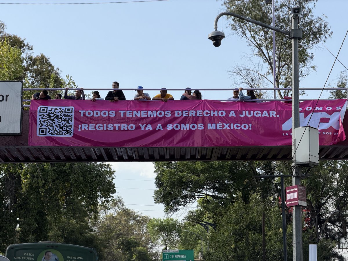 Activistas de SomosMX expresándose sobre el registro de su partido esta tarde, desde un puente peatonal en la Calzada de Tlalpan