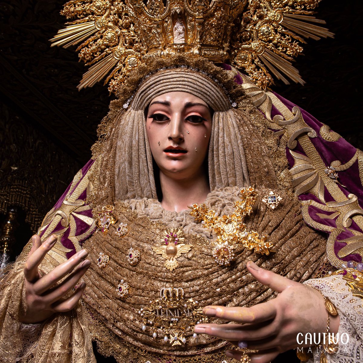 CULTO - María Santísima de la Trinidad Coronada ya preside su trono procesional, ataviada con saya y manto bordados en oro sobre terciopelo cardenal, para recorrer las calles de la ciudad en la salida penitencial del #LunesSanto26. #CofradíasMLG.