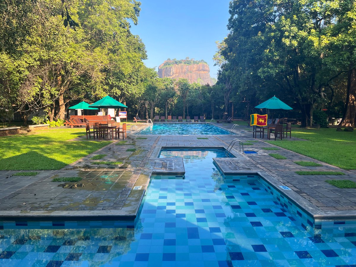Yuki4Travel's tweet photo. 【🇪🇸🦁ホテル•シーギリヤ🌴🪨】

📍Hotel Sigiriya , Sri Lanka)
(スリランカ、シギリヤにあるホテル)
世界中から観光客が来る人気宿泊先🍹✨

プールに浸かったり、ホテルフロントや横のバーでゆったりしながら、目の前に世界遺産のシギリヤ・ロック（ライオンロック）がドーンと大きく見えちゃうお勧め宿！
夜はロマンチックな景色も見れます🌳🐒

朝から夜までこの景色を独り占めして、
泳ぎながら歴史を感じれる最高の贅沢😍

#ホテルシーギリヤ #スリランカ #ライオンロック

✍️注意事項⚠️
①シーギリヤロックまで近いけど、登山口の入り口まではここからは歩くことは歩けるけど実際は地味に遠いです。
朝は道の途中に自然のゾウさんが歩いてることも🐘🦣🇱🇰
車を借りてるならドライバーさんに頼むことをお勧め！！
(ドライバーに早朝頼むのは可哀想とか待たせるの悪いとかは気にしなくていいのです)
※その分チップは渡して...欲しいですが

②①同様ピドゥランガラロックも同じです🙌

③ここはビュッフェの夜ご飯つけることん勧めます！めっちゃ満足できるクオリティなのと外に行くと意外と周辺がローカルすぎて探すの疲れたり、周りのお店がたまに停電したりするのでww(実体験あり)

④予約を早くしておく！！
ここめっちゃ人気なので予約するなら早く！2人で泊まれば普通にクオリティに対してめっちゃ安いです🤭

⑤コンビニとか近くにないのでお菓子とかお酒とかつまみを部屋で楽しみたいお方は道中のスーパーで爆買いしておくことをお勧めします🫡
※ダンブッラで買うのがよいです！
むしろその先は買えるチャンス減