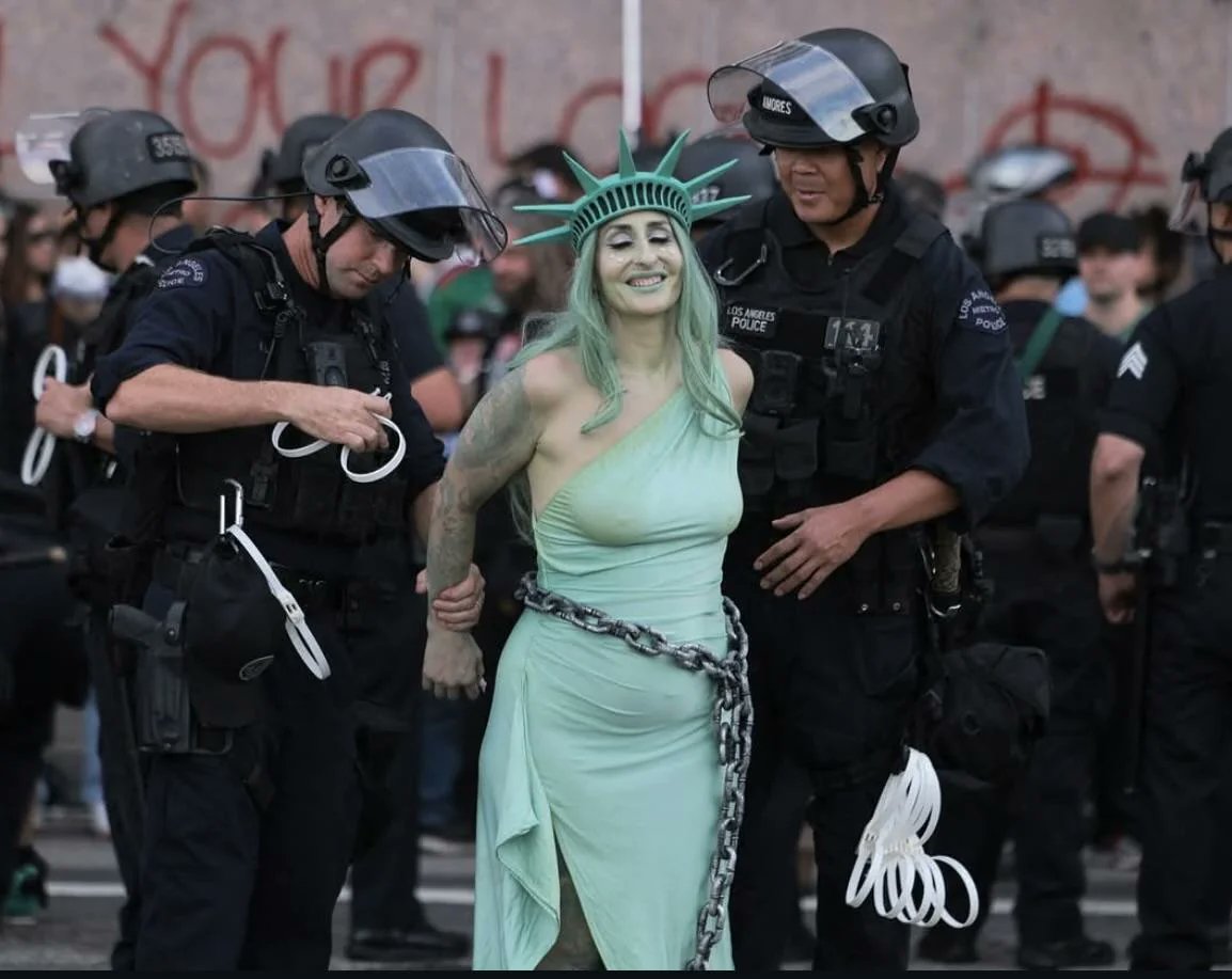LAPD officers arrest a protester dressed as the Statue of Liberty during No Kings protest