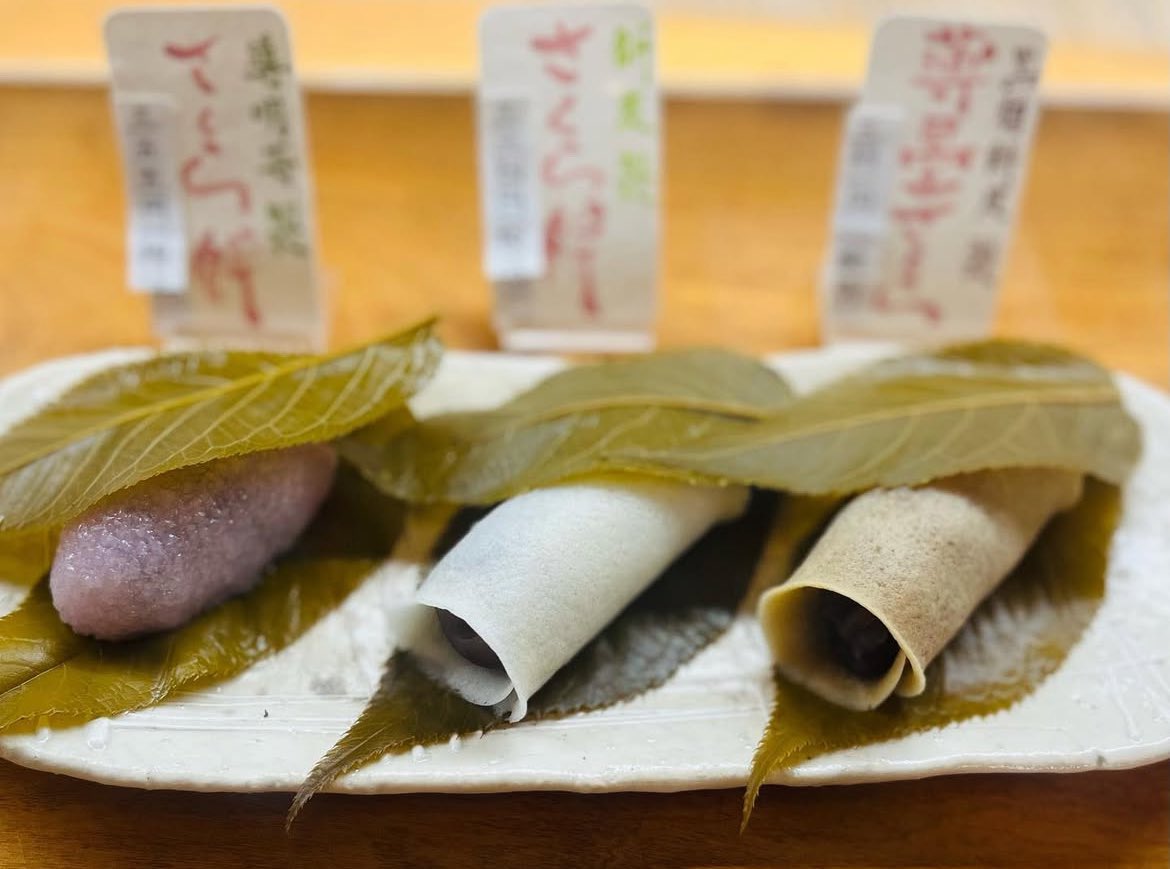 wagashibuyer's tweet photo. #販売情報　#桜餅大作戦

ゴメンなさい🙇‍♀️ 新潟県から福井県へと移動して、あちこち回っているうちにご案内を失念…明日3/31は #国立 の #一真菴 さんの道明寺桜餅と２種類の長命寺桜餅の合計３種類の #桜餅 の詰合せをお届けします！ラスト2日は、名古屋のDNAを感じさせる見事な桜餅が登場します。

天気が下り坂なので非常に心配ですが、僕が北陸出張に出ていますため、洋菓子バイヤーの応援も頂きまして運びます。昨年も冷たい雨☔に打たれて大変だった記憶が…都内の桜も散ってしまいそう…

さて、一真菴さんの桜餅は、これまた素晴らしい味わいなので、ぜひとも味わって頂きたい。#長命寺桜餅 にはさらりとしたみずみずしい #こしあん を。もう流れて消えていくようなこしあんは、全身の細胞に浸み透りそう。

もう一つは、#黒糖 を加えた長命寺桜餅「#薄墨桜」には大納言小豆の #粒あん。これがとっても大きな小豆なんですよね。ほろりとしてたまらないのです。長命寺製の焼き皮タイプはこの２種類が入ります。

これにとろりと柔らかい #道明寺桜餅 が加わります。こちらもみずみずしく、とっても優しい口当たり。儚げな桜の花そのものを思わせます。何て優しいのだと感動すら覚えます。

#立川高島屋 でずっとお取引をさせて頂いておりました国立の銘店。残念ながら百貨店区画の営業を終了しましたので、その味わいをご紹介したく、ちゃんと受け継いで繋いでいきたいと思い、今年もご紹介させて頂きます。そう、あの #茗荷谷 の #一幸庵 さんの愛弟子でもいらっしゃいます。

日本橋・新宿・横浜・玉川・柏 #高島屋 の５店舗に運びますが、何ぶん、#国立 の本店を10時に出発しての運搬ですので、雨の影響もあり、お時間を要します。午後1時までには到着するかと思いますが、新宿・横浜・玉川高島屋は、お電話でのお取置きが可能🉑です。

3個入　税込1,190円
※各店15箱限り