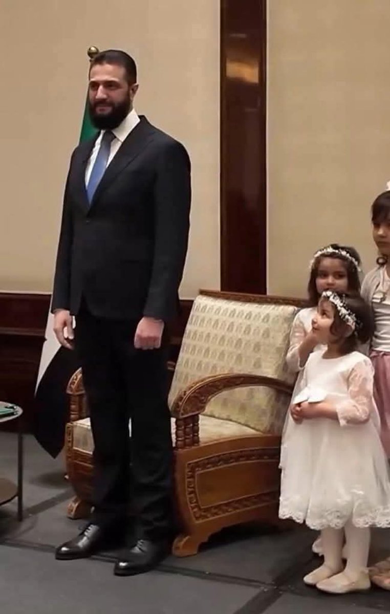 Little princess stealing the spotlight with her big smile, standing proudly beside the President. She knows her bright future is in safe, loving hands. 
#Syria #Germany #AhmedAlSharaa
#BerlinVisit
 #سوريا
#أحمد_الشرع
#برلين