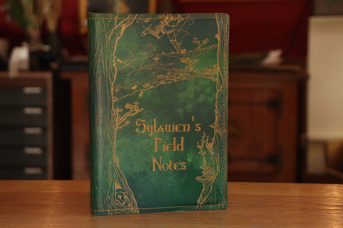SpeechlessBard's tweet image. A recent custom commission: green leather painted for extra depth, engraved with our Ranger design and inlaid with gold. You can always swap out the notebook inside for a new one, or get yourself a sketchbook 📚️ 
#ttrpg #notebook #leathercraft