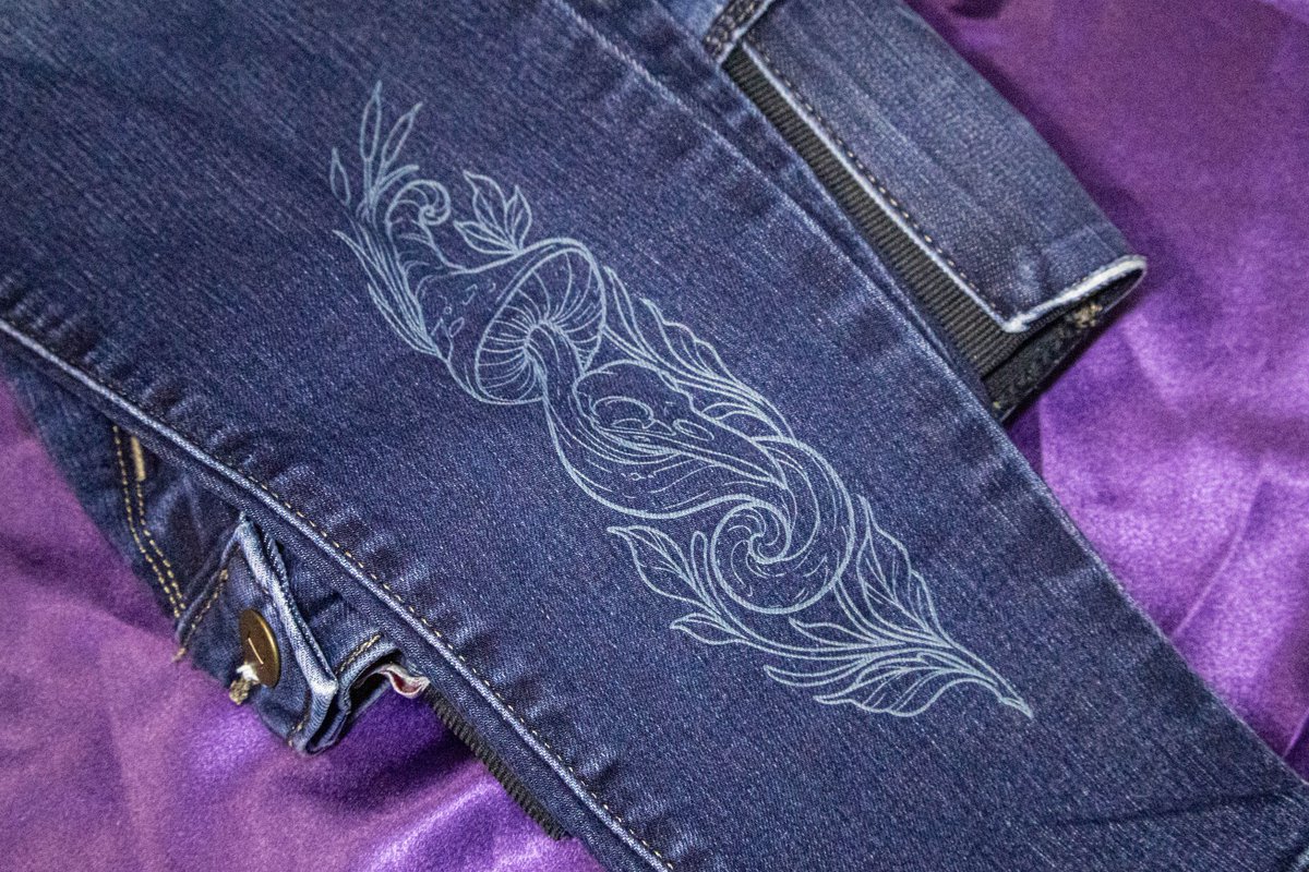 __VoidCat__'s tweet photo. Dark denim jeans with intricate mushroom and skull botanical illustration. 
Eyed a pair of old jeans in the closet and asked myself, what can I do with these before donating them? 
Spoiler: they became food for the laser.  Check it out and get 200 FREE credits to start! https://t.co/hBaF7SII3l #Atomm