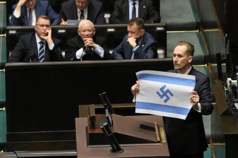 luantinz's tweet photo. A Polish member of parliament displayed an Israeli flag bearing a "Nazi" symbol in parliament. https://t.co/izKf4zNN3o