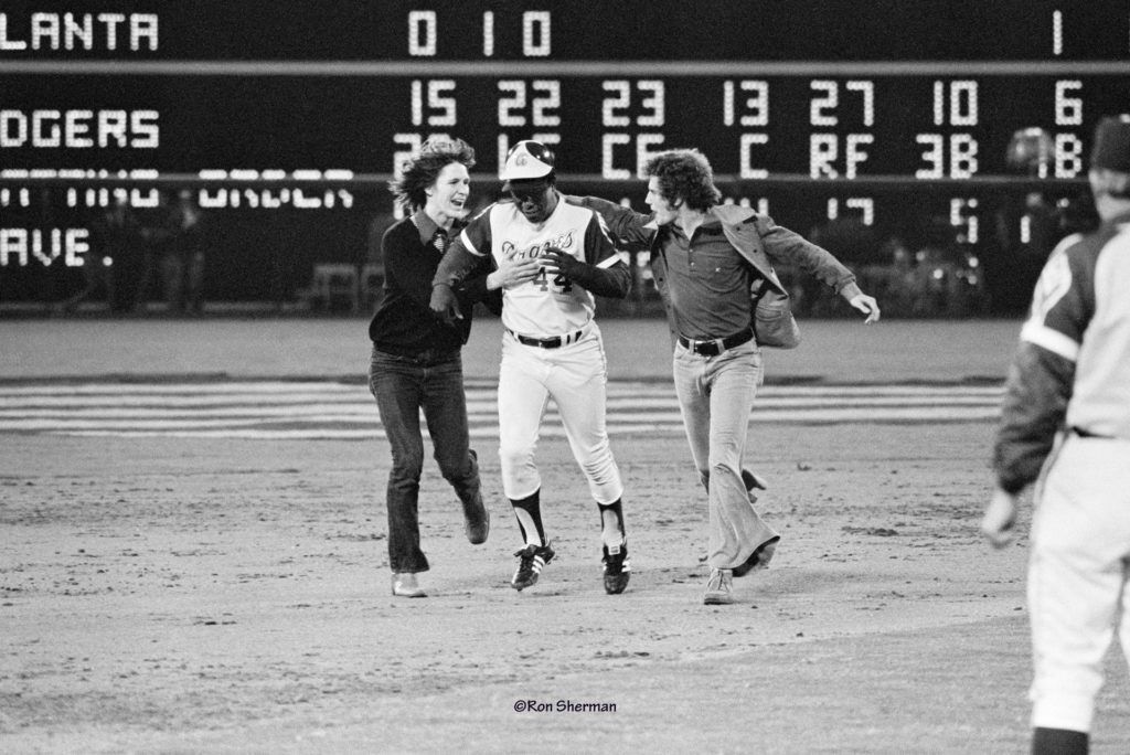 Teenagers Britt Gaston and Cliff Courtenay with Hank Aaron as he rounds the bases on his 715th home run. They received $100 fines. Their sentences were suspended after Aaron helped get the charges dropped.