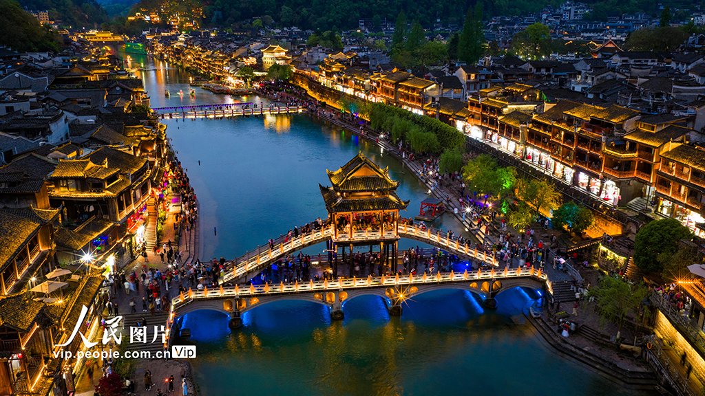 PDChinese's tweet photo. 【湖南：鳳凰古城夜色美】4月13日晚，湖南省湘西土家族苗族自治州鳳凰古城燈火璀璨，遊人如織。沱江波光與兩岸吊腳樓交相輝映，繪成一幅迷人的夜色畫卷。 https://t.co/0KH2hAPWZ4