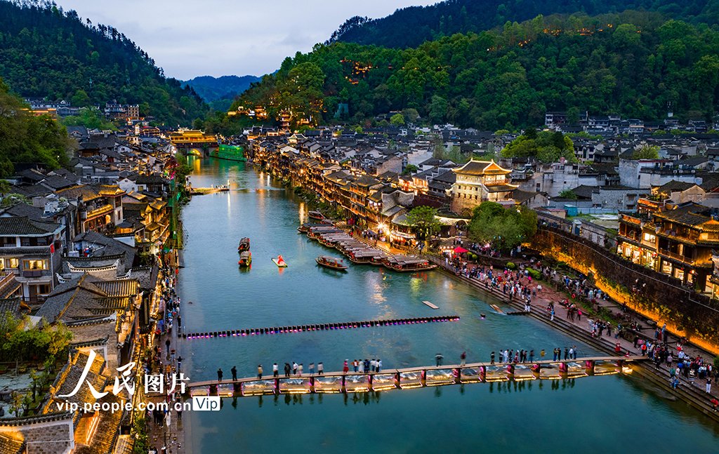PDChinese's tweet photo. 【湖南：鳳凰古城夜色美】4月13日晚，湖南省湘西土家族苗族自治州鳳凰古城燈火璀璨，遊人如織。沱江波光與兩岸吊腳樓交相輝映，繪成一幅迷人的夜色畫卷。 https://t.co/0KH2hAPWZ4