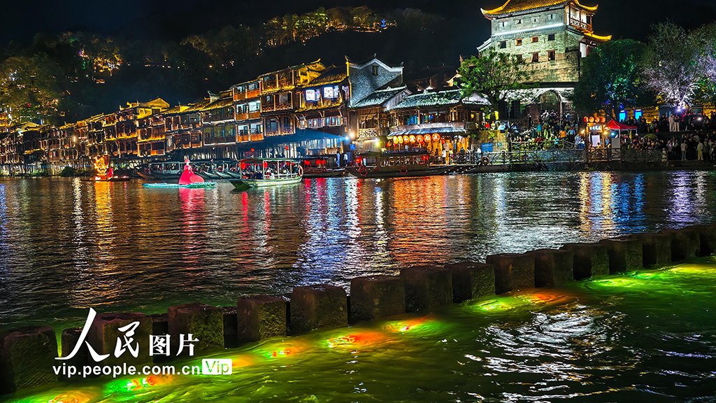 PDChinese's tweet photo. 【湖南：鳳凰古城夜色美】4月13日晚，湖南省湘西土家族苗族自治州鳳凰古城燈火璀璨，遊人如織。沱江波光與兩岸吊腳樓交相輝映，繪成一幅迷人的夜色畫卷。 https://t.co/0KH2hAPWZ4