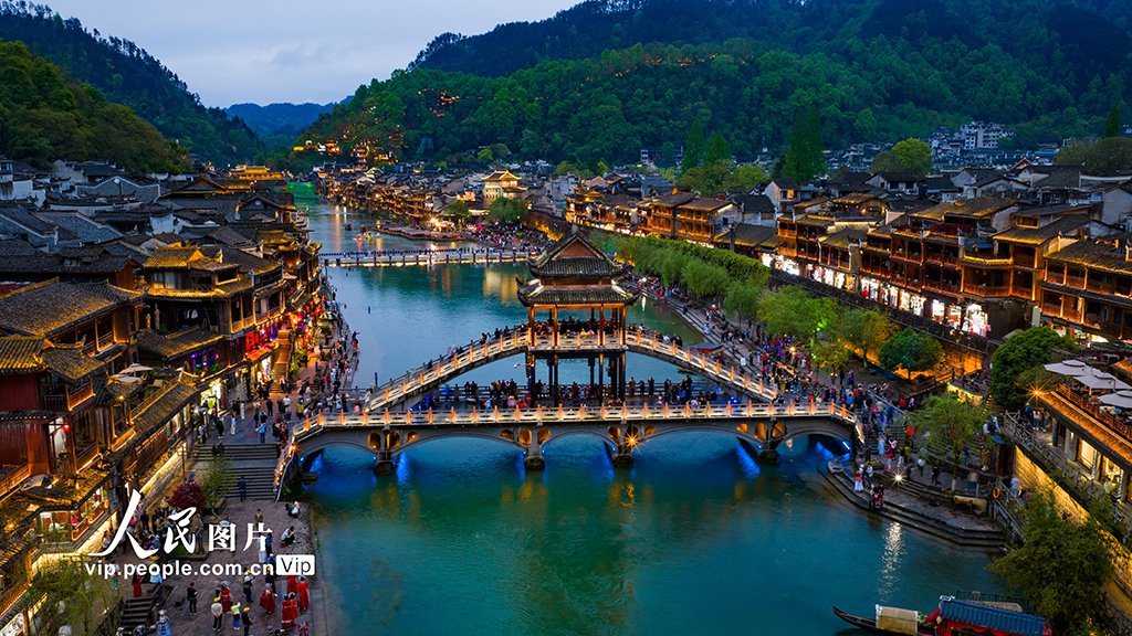 PDChinese's tweet photo. 【湖南：鳳凰古城夜色美】4月13日晚，湖南省湘西土家族苗族自治州鳳凰古城燈火璀璨，遊人如織。沱江波光與兩岸吊腳樓交相輝映，繪成一幅迷人的夜色畫卷。 https://t.co/0KH2hAPWZ4