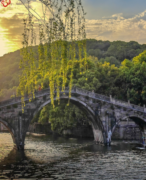 i_yuyao's tweet photo. As the sun sets, willow branches gently drape over an ancient stone bridge spanning a tranquil river. The scene, bathed in golden hues, is a poetic blend of nature and history, evoking timeless serenity. 🌅🌿 #SunsetSerenity #AncientBridge https://t.co/VbVxurmzsJ