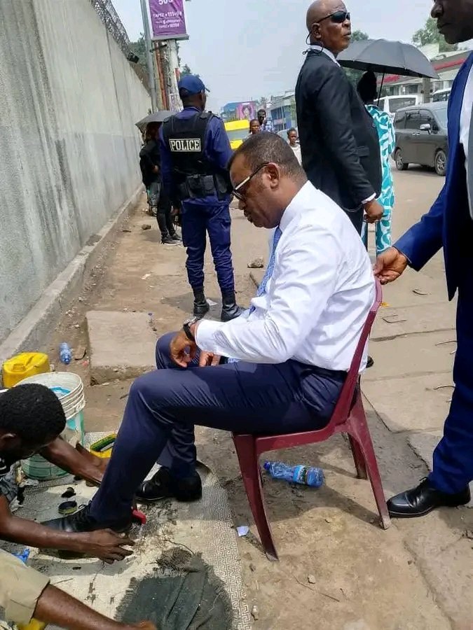 Tikennzende604's tweet image. Arrêt sur image : en pleine rue de Kinshasa, le VPM de la Fonction publique, JP Lihau, fait le choix de la proximité. Loin des bureaux et du protocole, il s’installe simplement sur une chaise, échangeant avec un travailleur du secteur informel en plein exercice de son métier.
Tk