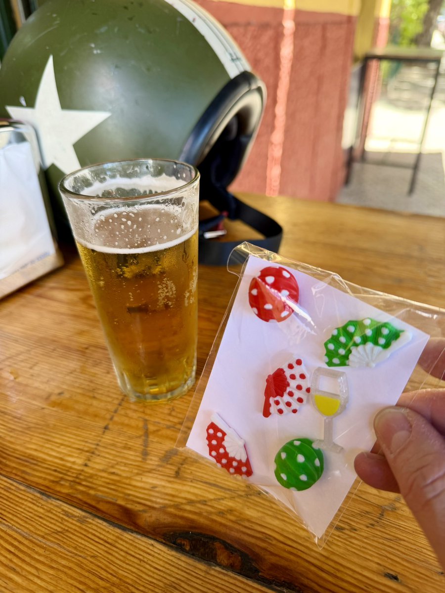 Ea! Uno que se para 'sin querer' a remojar el gañote, y le colocan unos pins para lo que se viene. Farolillos y abanicos, rojos y verdes.