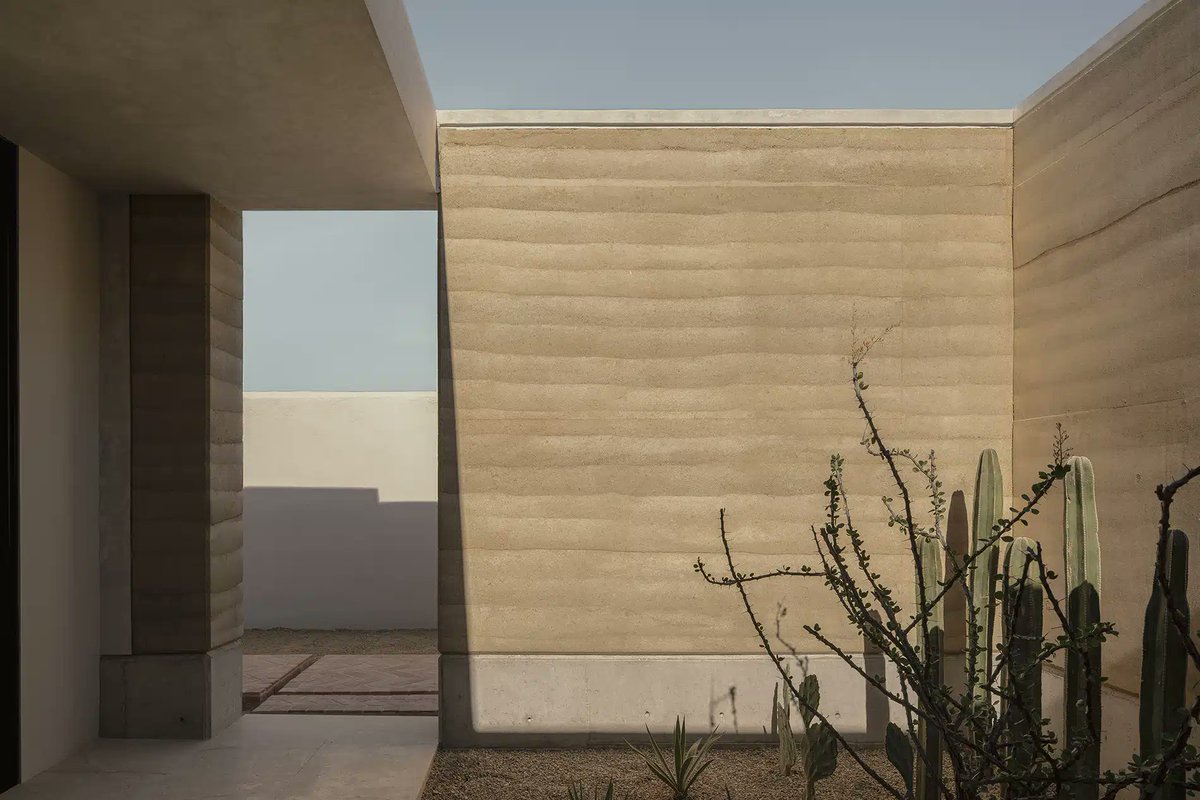 Arquine's tweet photo. Casa del Este, en Los Cabos (México), se integra al paisaje desértico mediante un patio central articulado con muros de tierra compactada, creando un refugio donde la naturaleza dicta el ritmo de vida. 
Un proyecto de JVL Arquitectos. | https://t.co/YOxyfMISbd https://t.co/bK1lnkI51h