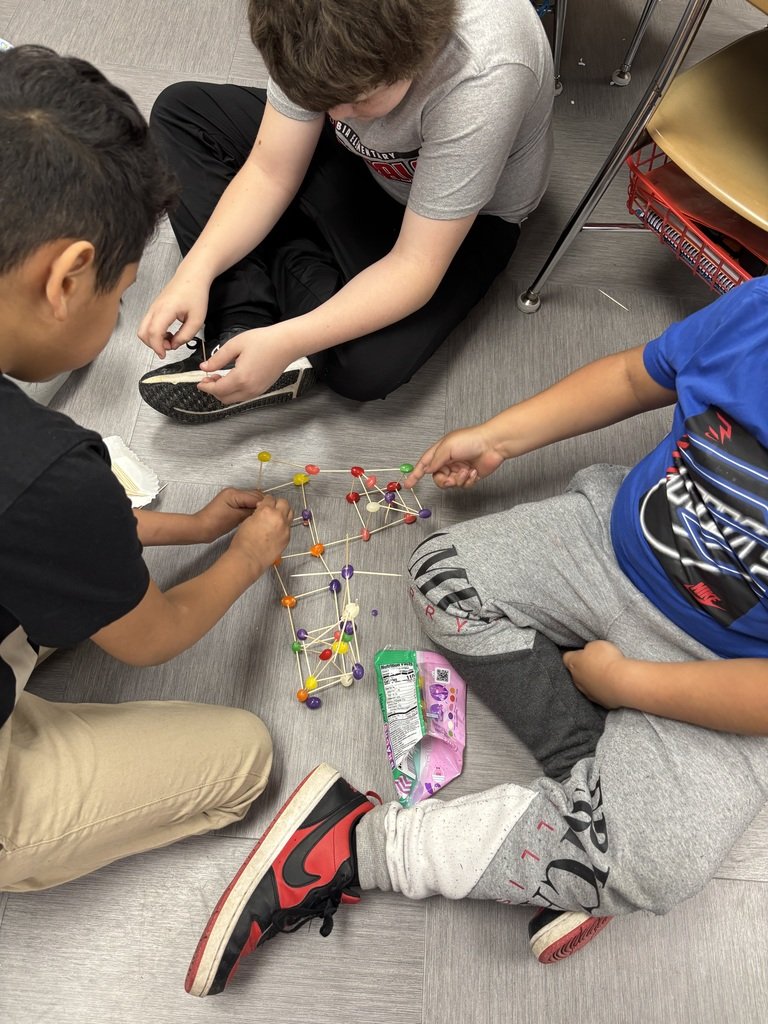 Mrs. Cole’s 1st grade class is making shapes with Mr. Maggart’s 4th grade class with toothpicks and jelly beans.