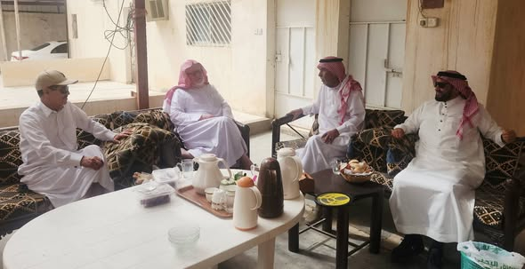 azizkasem's tweet photo. مِن واشنطن إلى مَراح الإبل..
سيرةُ وفاءٍ وحنينٍ لا تنطفئ.
.
أيُّ سِرٍّ هذا الذي يجعلُ رجلًا يطوفُ بأمريكا، ويتقلبُ في أعطاف "بلاد العم سام" عقودًا، ثم لا يطمئنُّ قلبه، ولا يجدُ راحته، إلا حين يعودُ إلى تراب قريته الصغيرة؟
.
وأيُّ خيطٍ خفيٍّ هذا الذي تنسجه نجدٌ في أرواح أبنائها، فلا تستطيعُ المدنُ الكبرى ولا السنواتُ الطوال أن تقطعه؟
هذا السؤال دهمني وأنا أجلسُ في رحاب ضيافة الأستاذ عبد العزيز الصعب "أبا عبد الله" في بلدة "الشِّعراء " ، وكنت بمعية صهره الدكتور محمد السعيدي، ويكملنا أبو مشعل عبدالرحمن البيز ..
وكلا الرجلين  أمضيا ست سنواتٍ في الولايات المتحدة، وتدرجا في معارج المناصب والمسؤوليات، فما إن أزاحا عن عاتقهما ثقل التقاعد، حتى أقبلا على "الشعراء" بقلبٍ يفيضُ صبابةً وشوقًا، وكأنه يغسلُ وعثاء الغربة في ظلال بيوتهما الطينية.
.
أما بطل قصتنا، فهو الأستاذ عمر البيز "أبو خالد"؛ والذي لا تبدأ سيرته من بهرج المناصب، بل من تلك البداية الشاقة التي تكشفُ جوهر الرجال.
.
تخيلوا معي؛ يدخلُ الفتى المدرسة الابتدائية وهو في الستة عشر من عمره!
.
في سنٍّ يأنفُ فيها أقرانه من الجلوس بين الصغار، لكن أبا خالد لم يأنف، بل مضى بإصرارٍ "فولاذي" يطوي المراحل طيًّا، حتى نال الثانوية، ثم عمل في هيئة الأمر بالمعروف والنهي عن المنكر، قبل أن يفتح له الله بابًا لم يحلم به؛ فسافر لأمريكا لينال البكالوريوس والماجستير، ويخدم وطنه ملحقًا تعليميًا هناك لأربعة عشر عامًا..
.
تتعجبون معي هنا، فرغم كل ذلك البريق، كان يهرعُ في كل إجازة بأبنائه نحو "الشعراء"، شوقاً لترابها الذي لا يعوضه "سياتل" ولا "ديزني لاند".
.
**عجبًا لهؤلاء القوم!**
أيُّ مغناطيسٍ هذا الذي سكن في ذرات رمال "الشِّعراء" ليجذب قلوبهم هكذا؟
.
أتأملُ حالهم وأتعجب؛ فالبلدةُ باتت اليوم هادئةً، تئنُّ تحت وطأة الصمت، ولا يسكنُ دروبها سوى الذكريات العتيقة، فيما الأبناءُ قد كبروا وتفرقوا في المدن الكبرى طلبًا للرزق في وظائفهم.. ومع ذلك، يتركون كل شيءٍ خلفهم، ويهربون من أضواء المدن وزحامها، ليعودوا إلى هذا السكون!
.
وكأن الذكرى عندهم أثمنُ من الحاضر، ورائحة الأرض أزكى من عطر المناصب.
.
يا لله ! ذهبوا بعيدًا في الأرضِ، لكنَّ قلوبَهم ظلَّت مربوطةً بوتدٍ قديمٍ في نجد.. هنا في بلدة "الشعراء".
.
هؤلاء الرجال ما هزمتْهم الغربةُ، ولا أغراهم بريقُ العالم؛ لأنَّ في داخلهم أرضًا أقدمَ من كلِّ المدن.
.
وهنا، ثنال من ذاكرتي بعض محفوظاتي إبان اليفاعة، والتي لم أدرك معانيها إلا اليوم ..مع هؤلاء الرجال.. الذين يلتقي مشهدهم بذلك الفيضان الشعري القديم؛ فقد أولع الشعراءُ بنجدٍ حتى جعلوا من رمالها قصائد.
.
أول من يُستحضرُ هنا الصمّة القشيري، الذي ودّع نجدًا والدموعُ تسبق الكلمات:
**قِفا ودِّعا نجدًا ومَن حلَّ بالحِمى**
**وقلَّ لنجدٍ عندنا أن يُودَّعا**
.
ويصطف بجواره يزيد ابن الطثرية، الذي أرسل تلك الأبيات التي ما زالت تُنشد عبر القرون:
.
أَلا يا صَبا نَجدٍ لَقَد هِجتَ مِن نَجدِ
فَهَيَّجَ لي مَسراكَ وَجدًا عَلى وَجدِ
.
أَإِن هَتَفَت وَرقاءُ في رَونَقِ الضُحى
عَلى فَنَنٍ غَضِّ النَباتِ مِنَ الرَندِ
.
بَكَيتُ كَما يَبكي الحَزينُ صَبابَةً
وَذُبتُ مِنَ الحُزنِ المُبَرِّحِ وَالجَهدِ
.
إن أبا خالد وأبا عبد الله وأبا مشعل لا يفعلون إلا ما فعله ابن الطثرية في شعره؛ فالفرقُ الوحيدُ أن أولئك عبّروا بالقصيدة، وهؤلاء عبّروا بالعودة. وربما كانت العودةُ أبلغ من القصيدة، لأن القصيدة قد تقولها وأنت بعيد، أما العودةُ فلا تكون إلا إذا كان القلبُ قد حسم أمره، واختار أن ينهي رحلته حيث بدأت.. تحت سماء "الشعراء".
.
يا سادة:
ليست العظمةُ في أن تبلغَ أقاصي العالم، بل في ألَّا تفقدَ الطريقَ إلى بابك الأوَّل.. وفي آخرِ المطافِ، لا ينتصرُ للإنسانِ إلا ما أحبَّهُ بصدقٍ؛ ولهذا انتصرتْ "الشعراء".