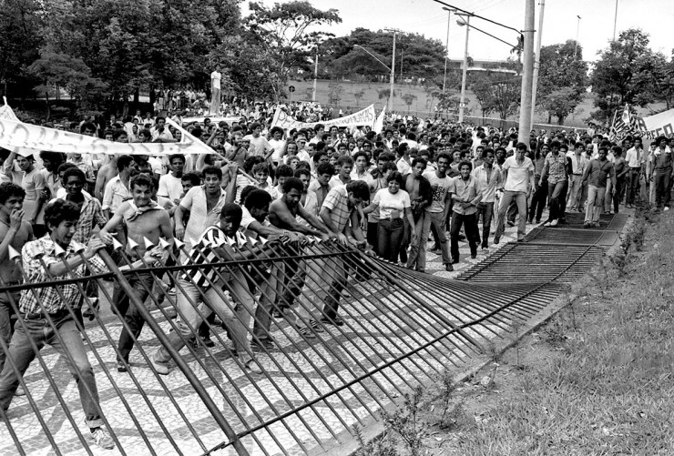 Manifestantes derrubam as grades do Palácio dos Bandeirantes, sede do governo do estado de São Paulo. Há 43 anos, em 4 de abril de 1983, eclodia na capital paulista o Motim Contra a Fome e o Desemprego.

A revolta popular surgiu como uma reação à grave crise econômica e social