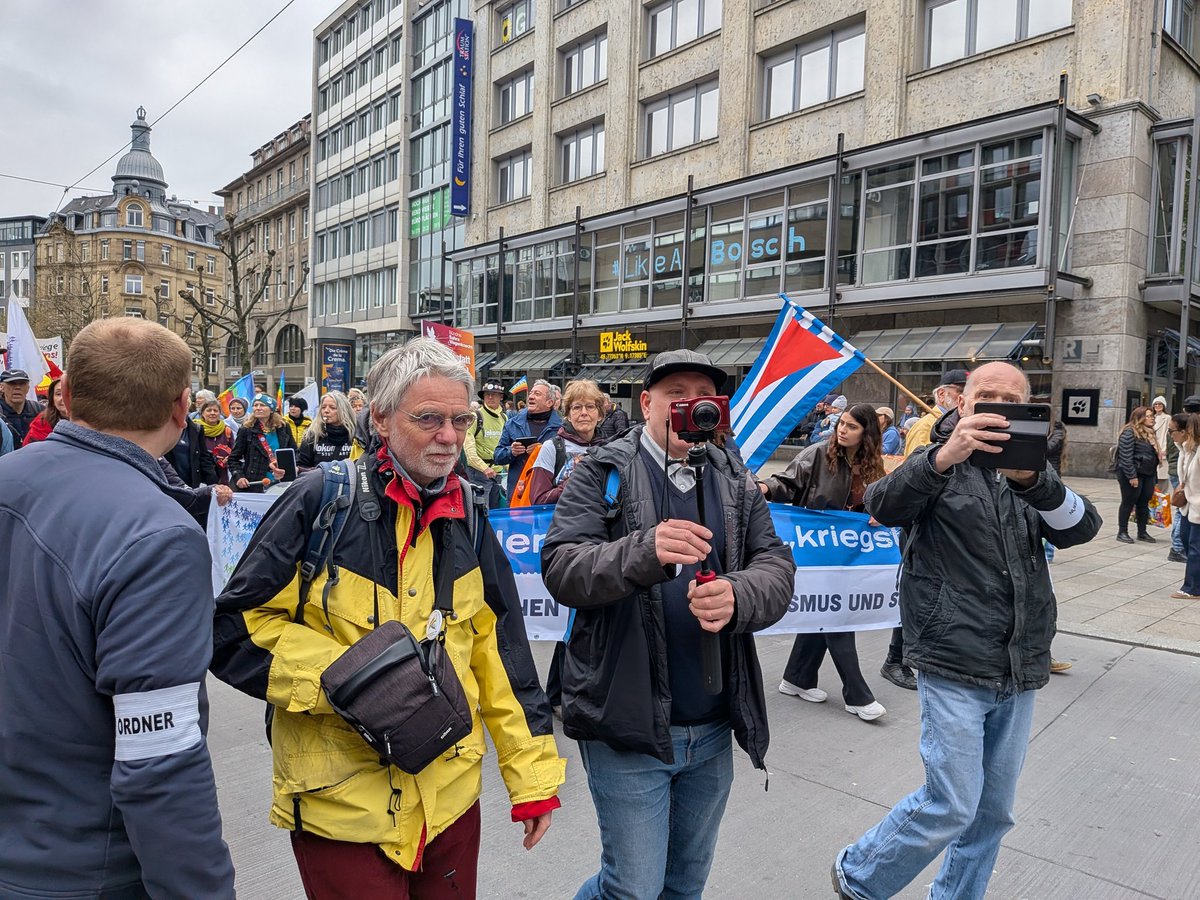 Gleich müssen sie an uns vorbei. Die „nette“ Dame am Anfang hatte sogar ihr Geschirrtuch auf dem Kopf getragen – passt ja zum Rest der Truppe hier beim Ostermarsch. Stuttgart auf der <a href="/ukraine_demo/">Ukraine-Demo in Stuttgart</a> zeigt klare Kante. 🇺🇦