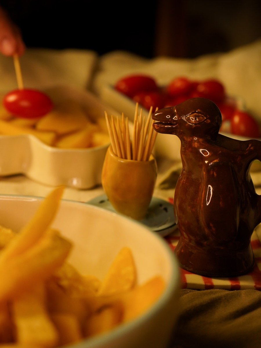 El típico pingüino, como el que tenía mi abuelo, hecho salero.
El plato enlozado, como el de mi abuela, con una empanada transformada en porta escarbadientes.

Un pedacito de esos domingos de almuerzo familiar de mi infancia convertido en decoración funcional 🤎