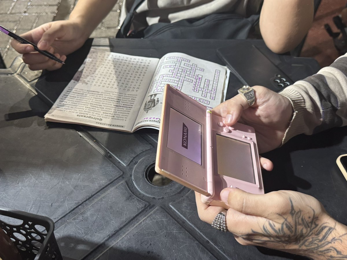 sai com um casal de amigos performaticos e enquanto espera o lanche um puxou um nds e o outro caça palavras