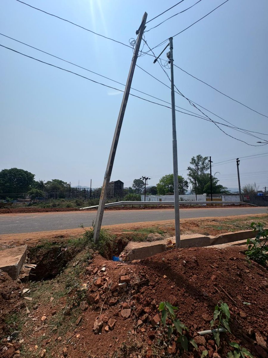 subhasishjc's tweet photo. This tilted electric pole carrying a live service line now stands inside an under-construction drain due to road works. 
Electricity &amp; Road works authorities are shifting blame.
Who shall be accountable if an accident occurs?
Immediate action required.
#PublicSafety #Electricity https://t.co/APDaLqBZXk