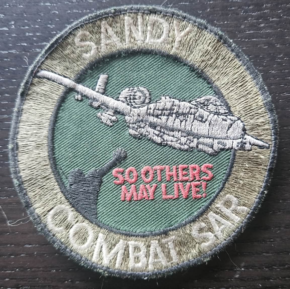 An old patch…  well-worn  (worn  proudly!)…  likely  passed  down  from  one  Sandy  to  another  in  a  heartfelt  ceremony  steeped  in  tradition  (and  a  little  humor!)…  an  expectation…  a  challenge...  an  honor…  a  continuation  of  a  commitment  to  one-another