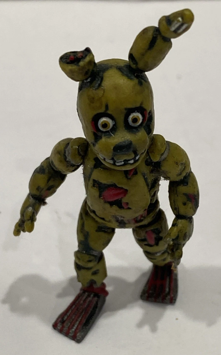 springfacts's tweet photo. While the Funko 2" Blacklight Springtrap figure still has the same withering as its regular counterpart, a lot of it on his arms and legs is painted over to be that of blue.
Unlike his legs, his pelvis and kneepads are also depicted as purple. https://t.co/8mmhzqmfOA