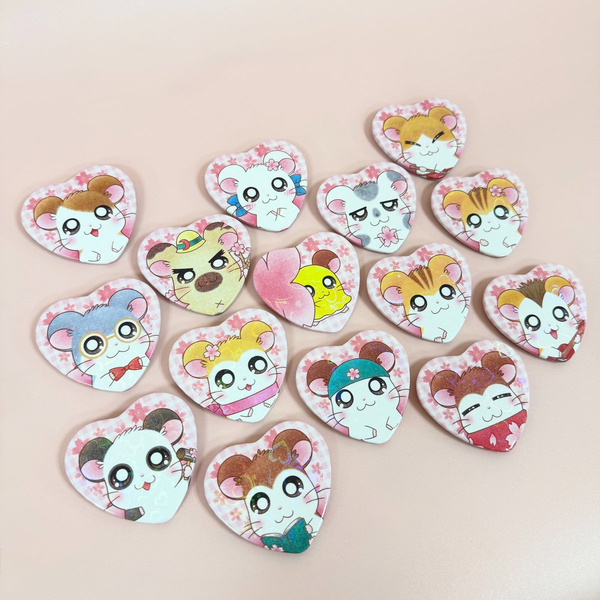 ttk86shop's tweet photo. 🌻‥∵‥‥∵‥‥∵‥‥🐹
#とっとこハムタウンショップ
　　　～商品紹介➀～
🐹‥∵‥‥∵‥‥∵‥‥🌻

4/23(木)のグランドオープンに向けて、順次グッズ情報をお届けします𓂃✧
本日紹介するのは・・・
／
『ハート型ホログラムカンバッジ(ランダム)』
＼
さくらの花びらにも見える👀🌸❔
角度によってキラキラ輝くホログラムがポイントです✨

📅2026年4月23日(木)OPEN
📍東京都渋谷区代々木3-8-3 PDスペース２F
🔗https://t.co/FCmqZayRnp

#とっとこハム太郎　#ハム太郎