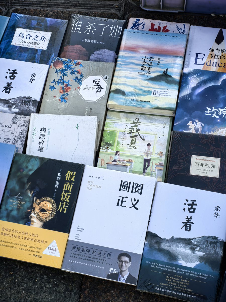 JDee1233's tweet image. Spotted a golden retriever volunteering at a street bookstall—she "guards" books while her owner helps customers. Tail wags nonstop, and passersby can’t resist stopping to say hi.  #StreetMagic #DogsofNYC