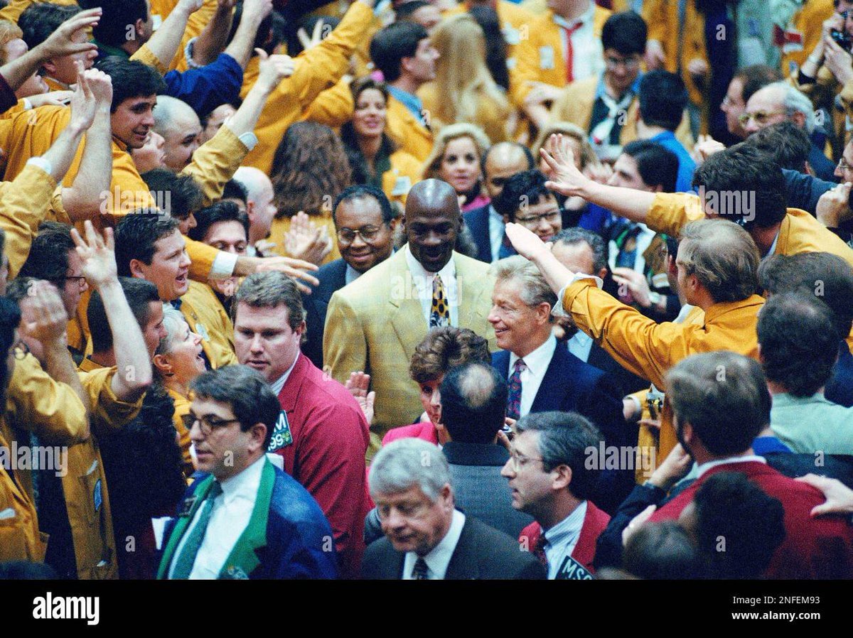 Basketball great Michael Jordan, center in yellow suit, tours the Chicago Mercantile Exchange with CME