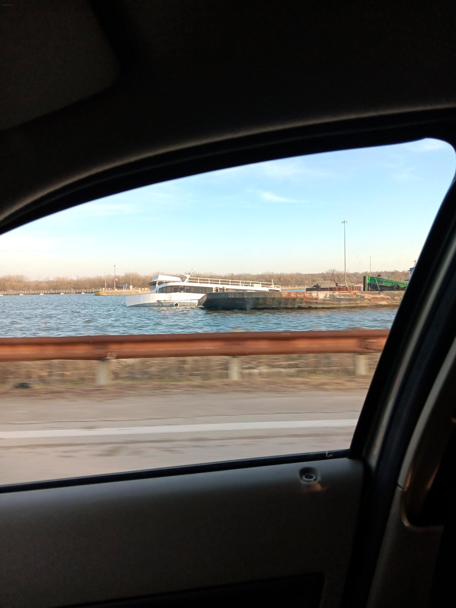 Haleyhhhx's tweet photo. Partially submerged boat off Rt. 6 in Joliet has been there since 2018! 🛥️ Repainted recently, but now it’s halfway underwater. Anyone know the story behind this? It’s been 3 weeks—seems like a long time to leave it like that. https://t.co/K0OnZgwUYb