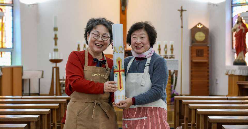 In Yangdeokwon parish in Hongcheon, South Korea, the Lux Society carves liturgical candles since 2017. Here is a photo of two members holding a Paschal candle carved by the group.