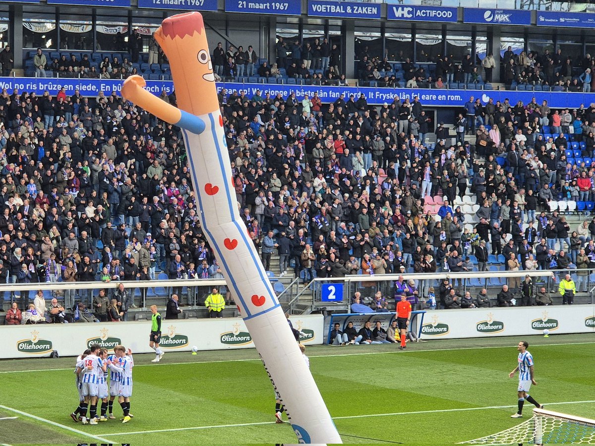 Ik moat faak laitsje om dy poppen dy't feest fiere neidat der in goal makke is.
Ik tink dan , der sit ien yn it stadion dy't op in knop drukt om se oan te setten. 
Wa is dy oansetter?