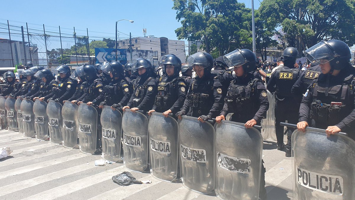 andread_gtv's tweet photo. Ahora en la USAC la @PNCdeGuatemala y @mingobguate hace cambio de agentes de la FEP y coloca en primera línea a mujeres, mientras al fondo siguen manifestantes de estudiantes contra Walter Mazariegos tras su reelección como rector. https://t.co/sVi964YIsw