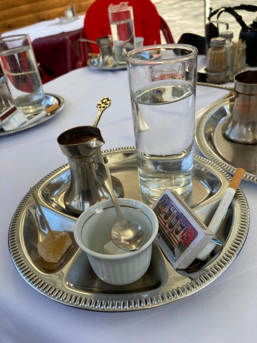 Rainmaker1973's tweet photo. When you order a coffee at Lutvina Kahva café in Travnik, Bosnia, it is served on a traditional tray with a Bosnian coffee set, a piece of rahat lokum (Turkish delight), a single Drina brand cigarette, and a box of matches. 

This practice is a nod to historical accounts and local lore, specifically linked to the era described in Ivo Andrić’s famous novel, The Days of the Consuls (Travnička hronika)