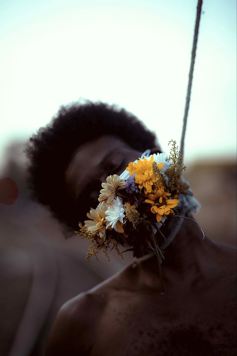 Faltou ar nos hospitais.A morte não veio só pela doença, veio também pela negação e pelo descuido. Essas flores cobrem a boca como memória de um tempo em que proteger o outro virou debate. Respirar sempre foi um pacto coletivo. Quando esquecemos disso, sufocamos o próprio futuro.