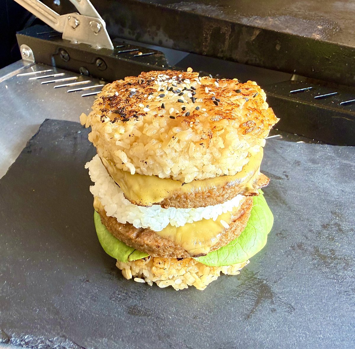 ErinnFL's tweet photo. To start the new week, I tried to make a rice veggie burger. Don’t know why I added a third rice bun, it just happened 😆 https://t.co/JuFn5fhsOT