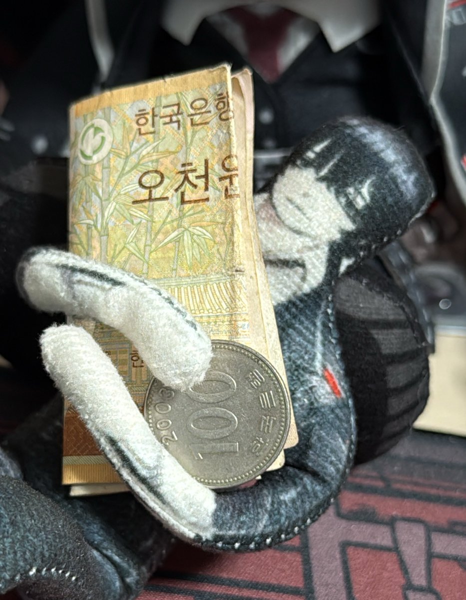 母国の金を大事そうに抱えるイ
