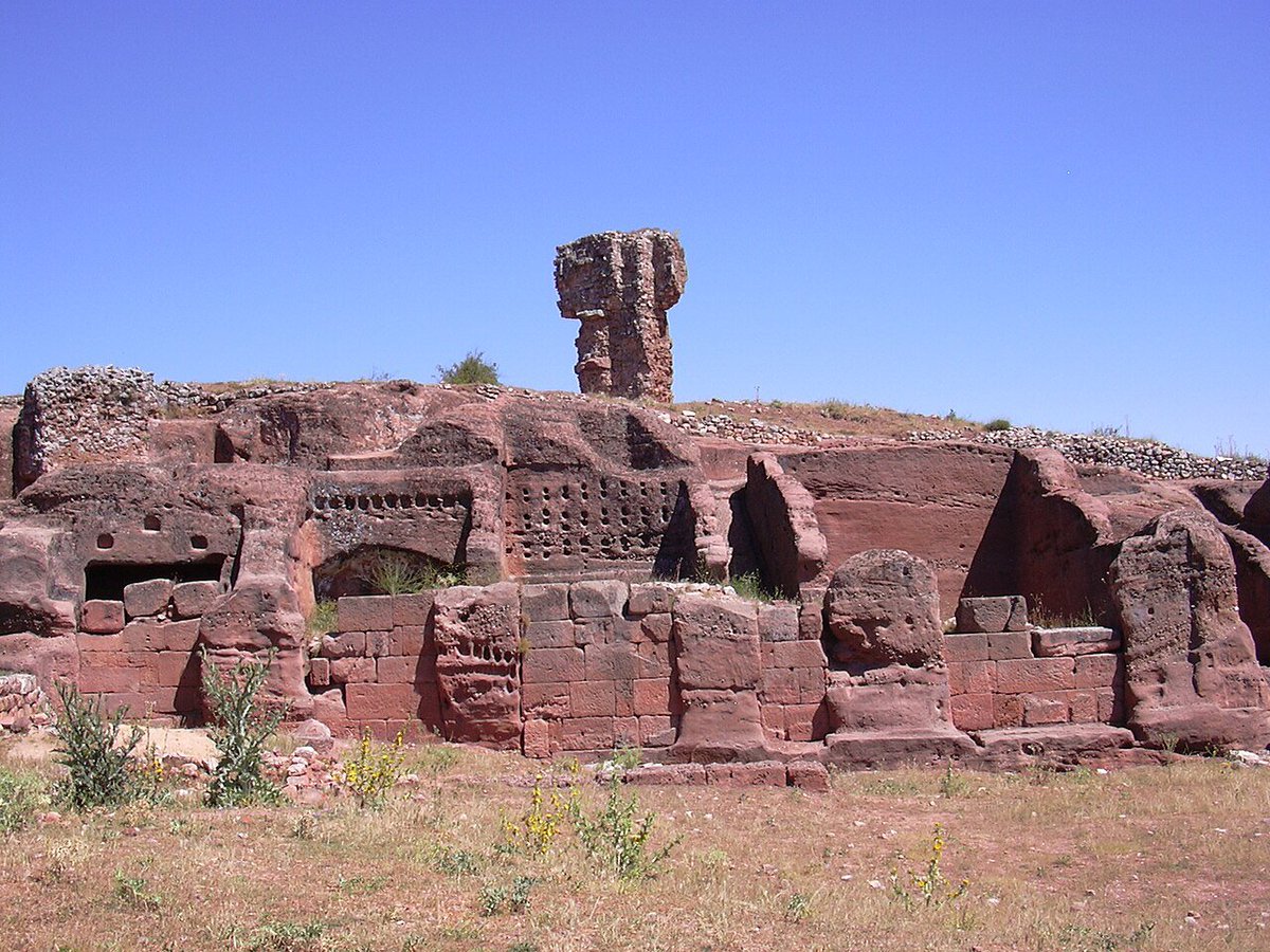 ElCampoAmarillo's tweet photo. Si alguna vez te has preguntado cómo sería vivir dentro de una montaña, tienes que conocer Tiermes. En Soria existe un lugar al que llaman la "Petra de Castilla" y no es un decir: es una ciudad entera que, en lugar de construirse hacia arriba con ladrillos, se esculpió directamente hacia dentro de la roca rojiza. 

​Lo que hicieron allí primero los celtíberos y luego los romanos es una maravilla de la ingeniería. En vez de acarrear materiales, usaron el pico para "sacar" de la piedra sus casas, los canales de agua e incluso las gradas de un teatro. Es arquitectura en estado puro: aprovechar lo que la naturaleza te da para crear un refugio que, literalmente, forma parte del paisaje. 

​Tiermes nos da una lección de humildad. En un mundo donde hoy solemos hormigonarlo todo para que el suelo sea plano, ellos se adaptaron a cada curva de la roca. Nos enseñan que la verdadera sostenibilidad no es algo moderno, sino algo que nuestros antepasados ya practicaban por puro respeto al entorno y al clima soriano. 

​Si vas, fíjate en las marcas de los picos en las paredes. Es una sensación extraña: te das cuenta de que el patrimonio no es algo lejano o intocable, sino el rastro del esfuerzo de gente que, hace dos mil años, tenía las mismas ganas de construir un hogar que nosotros hoy.