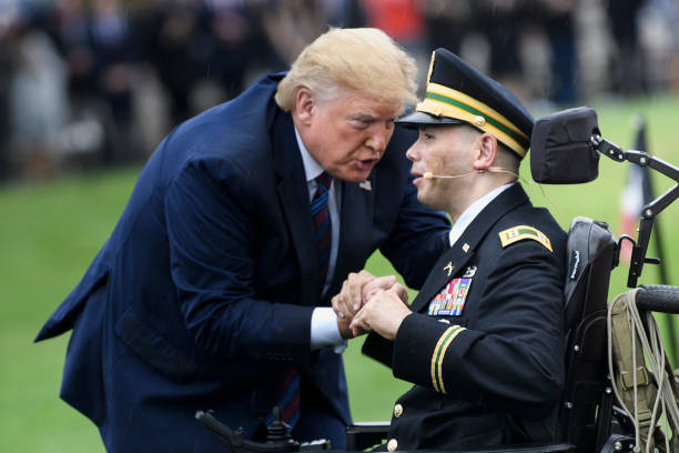 US President Donald Trump embraces Army Captain Luis Avila, who sang God Bless America on September 30, 2019