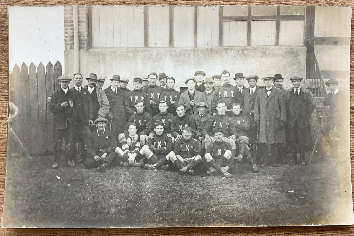PaulSuttonKing's tweet image. The #postcard week starts with a bang. Today’s Monday mystery appears to be football related. We used plenty of TNT during WW1 but is this in any way related. Most of the factories were staffed by women. Chap on the left has a distinctive badge on his jacket. Any ideas?