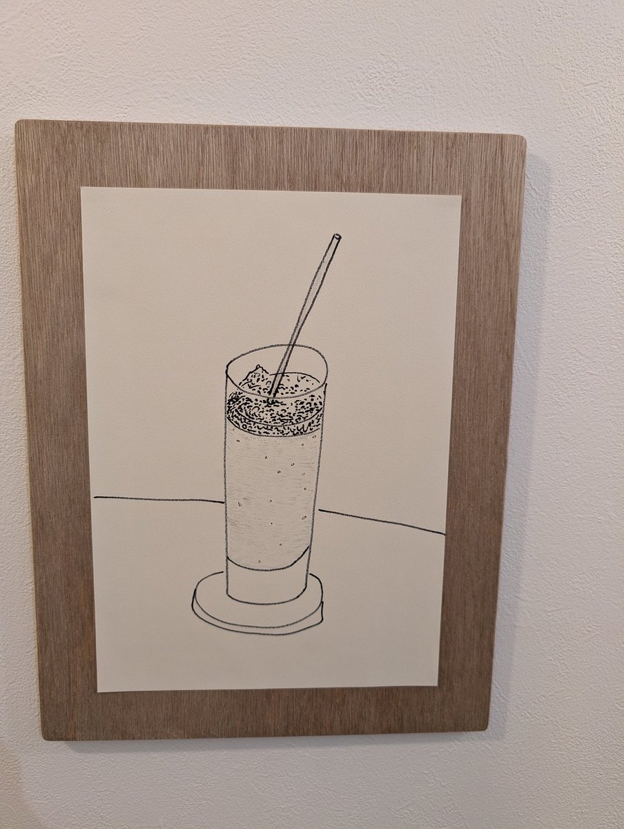 この絵も、逆の意味でポップだった。凹凸のある白い紙に炭かクレヨンで描いたような質感のモノクロのシンプルな絵なのだけど、デザイン絵のよう。日の丸構図のようだけど、ストローが微妙に傾き、均等な構図からずれている。建物の絵もそうだけど、形のゆがみが魅力になっている。
