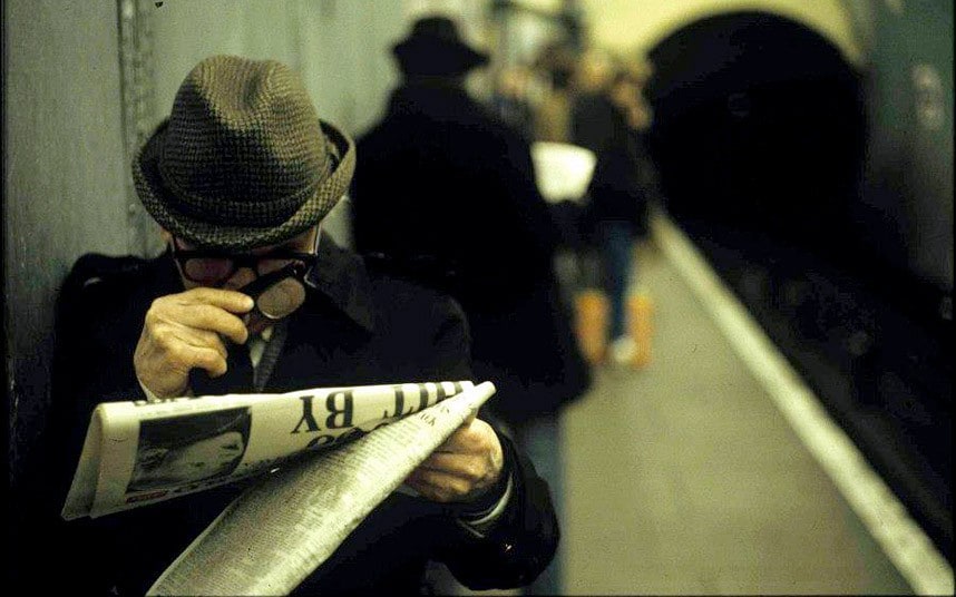 Deep in the headlines on the London Tube. England, 1970-80s by Bob Mazzer