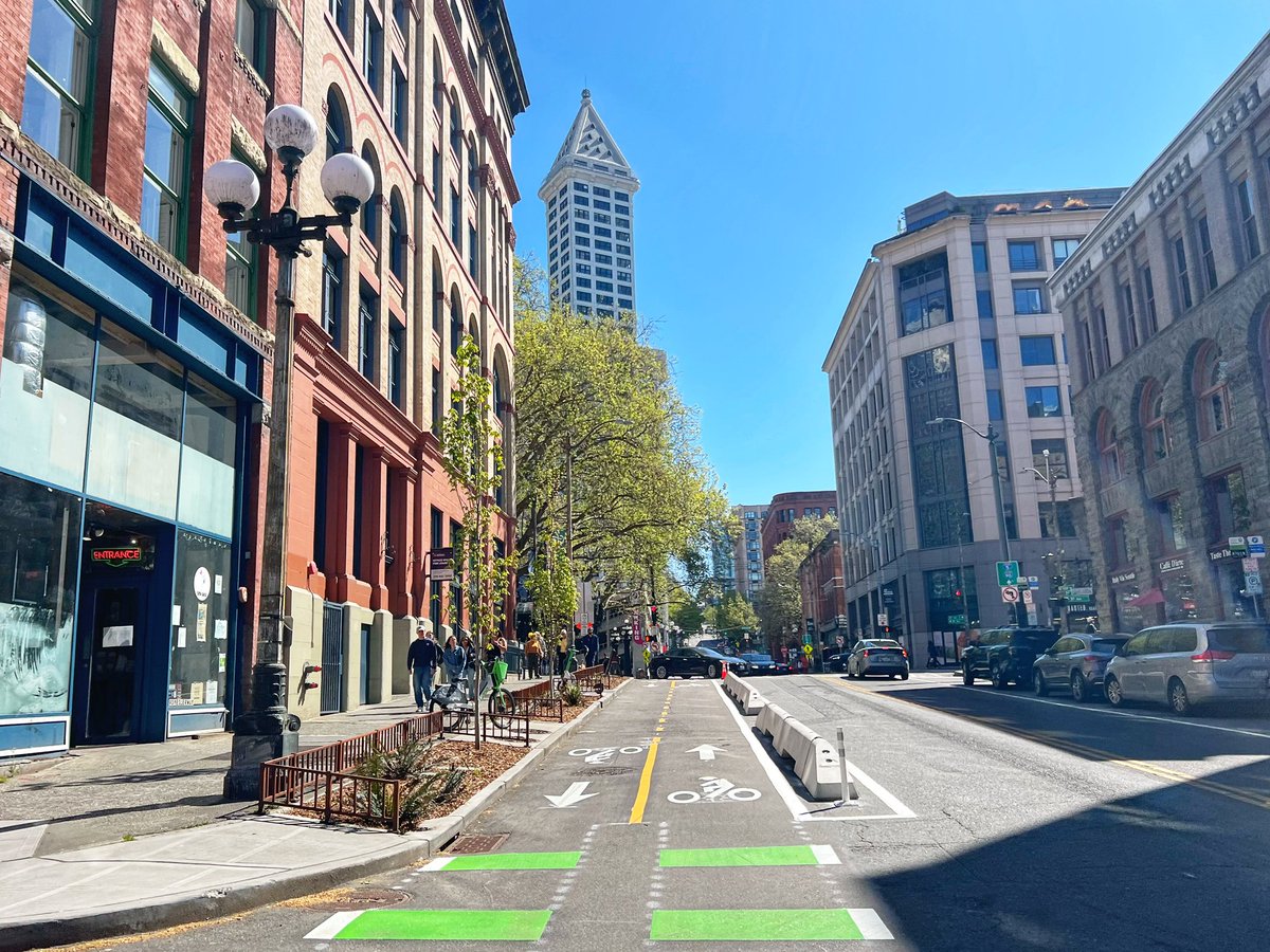 Qagggy's tweet photo. The Yesler Gap, before and after, now linking Seattle’s first downtown protected bike lane to its newest. https://t.co/iHcxCFllJj